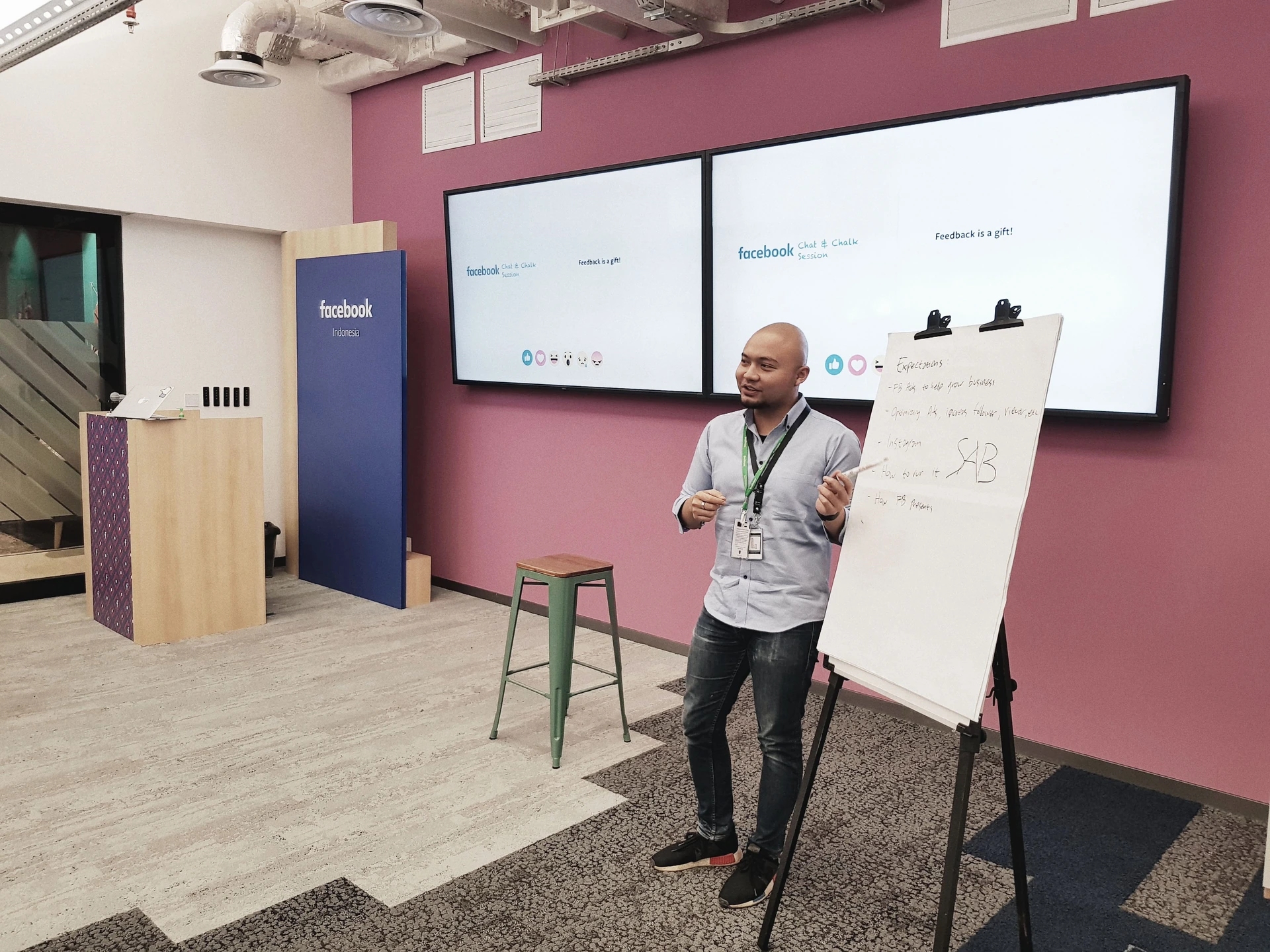Tri Lastiko sharing ideas in a workshop, beside a presentation board